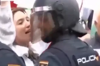 “Policía y su esposa en manifestación se miran en silencio durante protesta en España”